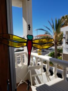 a stained glass butterfly chandelier hanging from a balcony at The Magic Dragonfly! in Santa Cruz de Tenerife