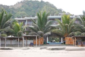 a hotel on the beach with palm trees in front of it at Vistazul Rentals in San Clemente