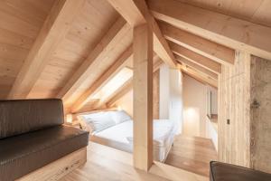 una camera mansardata con letto e divano di Alla Stazion Locanda nelle Dolomiti a Pieve di Cadore