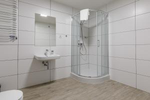 a white bathroom with a shower and a sink at AQUA HOUSE in Sopot
