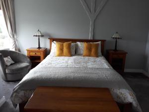 ein Schlafzimmer mit einem großen Bett und einem Stuhl in der Unterkunft Mill Lane in Buncrana
