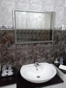uma casa de banho com um lavatório e um espelho em MiaMea Apartment em Tuheljske Toplice