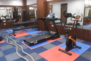a gym with a treadmill and exercise equipment on the floor at Hotel Millenia Regency Lucknow in Lucknow
