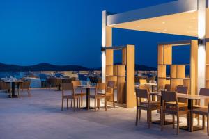 ein Restaurant mit Tischen und Stühlen auf dem Dach in der Unterkunft Elounda Breeze Resort in Elounda
