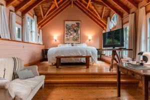 a bedroom with a bed and a tv in a room at Las Balsas Relais & Chateaux in Villa La Angostura
