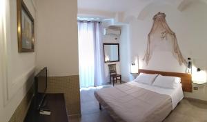 a bedroom with a bed and a television in it at Hotel Vittorio Veneto Napoli in Naples