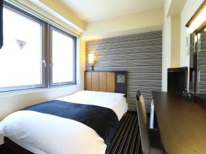 a bedroom with a bed and a desk and window at APA Hotel Shibuya Dogenzakaue in Tokyo