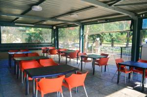 a restaurant with tables and chairs and windows at Essenwood Park Hotel in Durban
