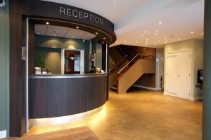 a lobby with a reception counter and a staircase at Hotel Arrows in Uden