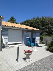 un patio avec un banc et un vase de fleurs dans l'établissement Gite - Le chemin blanc, à Saint-Sornin 11 autres photos