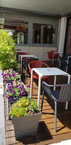 einen Tisch, Stühle und Blumen auf einer Terrasse in der Unterkunft ibis Annemasse-Genève in Ambilly