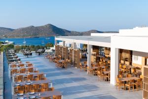 a rendering of a restaurant with tables and chairs at Elounda Breeze Resort in Elounda