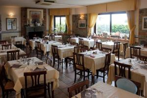 a restaurant with white tables and chairs and windows at Ponti di Badia in Castiglione della Pescaia