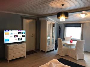 a living room with a dining table and a television at Kvamseter Lodge - Mountain Apartments in Norheimsund