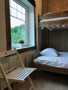 una camera con letto a castello, sedia e finestra di Kvamseter Lodge - Mountain Apartments a Norheimsund