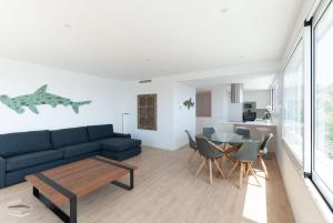 a living room with a blue couch and a table at Vista Roses Mar - Ancla Mar in Roses