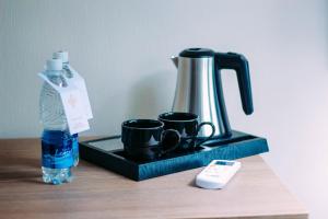 a tray with two coffee cups and a bottle of water at Osh Grand Hotel Chavo in Osh +19 photos