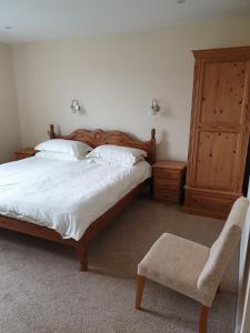 a bedroom with a large bed and a chair at the old red lion in Bruton