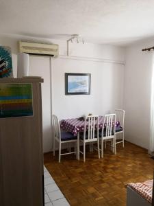 jadalnia ze stołem i krzesłami w pokoju w obiekcie Apartments "Laci" w Krku