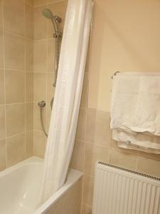 a bathroom with a shower with a white shower curtain at the old red lion in Bruton +41 photos
