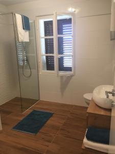 ein Bad mit einem Waschbecken, einem WC und einem Fenster in der Unterkunft Stone & Salt Getaway Home in Šimuni