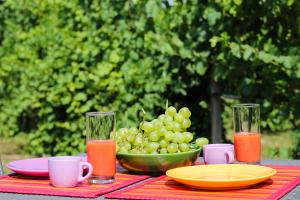 a table with a bowl of grapes and a plate of juice at La petite maison in Sirmione