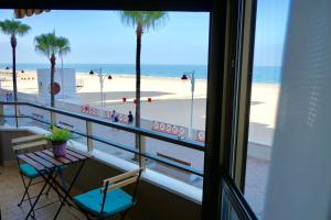 balcón con vistas a una playa con palmeras en Victoria Beach Sunset Lounge, en Cádiz