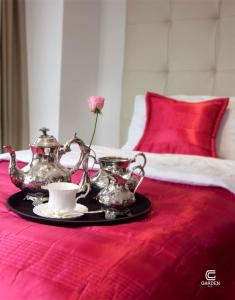 a tray with a tea set on a bed at Garden Spa Boutique Hotel in Skopje