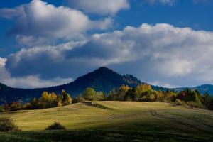 a green field with a mountain in the background at U Martinov in Poniky