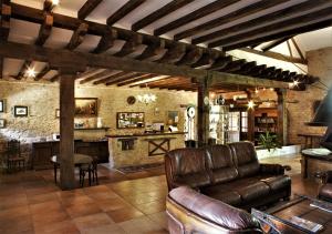 a living room with a leather couch and a bar at Domaine de Vareilles in Vareilles