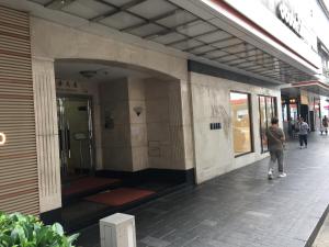 un hombre caminando por una acera fuera de un edificio en Seasons Hotel - Causeway Bay, en Hong Kong