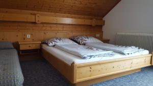 sypialnia z drewnianym łóżkiem z 2 poduszkami w obiekcie Gästehaus Pehab w mieście Gröbming