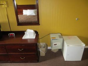 een kamer met een bed, een dressoir en een spiegel bij Americourt Hotel and Suites - Elizabethton in Elizabethton