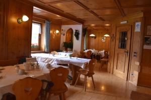 a restaurant with tables and chairs in a room at Garni Haus Tyrol in Corvara in Badia