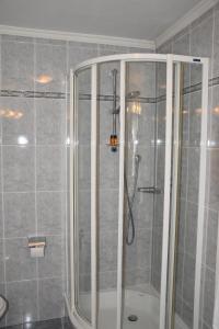 y baño con ducha y mampara de cristal. en Garni Haus Tyrol en Corvara in Badia