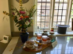 una mesa con jarras y un jarrón con flores en Oak House Farm en Edenbridge