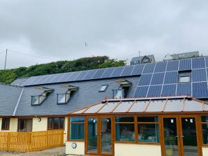 um edifício com painéis solares em cima em Barmouth Beach Club em Barmouth