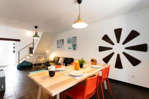 kuchnia i salon z drewnianym stołem i pomarańczowymi krzesłami w obiekcie Casa da Mó - Santo Isidoro w mieście Santo Isidoro