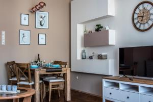 a dining room with a table and a tv at Hangulat apartman in Miskolc