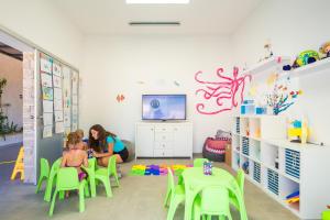 two girls sitting at a table in a room at Mobile Homes Camping Santa Marina, Lanterna in Poreč