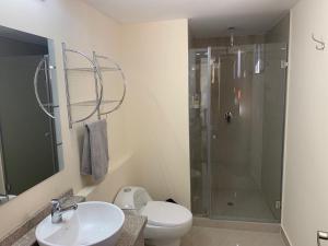 a bathroom with a shower and a toilet and a sink at Los Angeles Stay Inn in Quito +11 photos