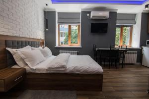 ein Schlafzimmer mit einem Bett und ein Esszimmer mit einem Tisch in der Unterkunft LUX Apartment near Arena City in Kiew