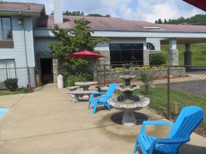 un grupo de sillas azules y una fuente frente a una casa en Americourt Hotel - Mountain City, en Mountain City