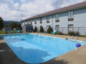 a large blue swimming pool in front of a building at Americourt Hotel - Mountain City in Mountain City
