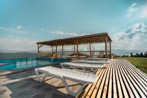 a group of white benches sitting next to a pool at Tsovasar Family Rest Complex in Sevan
