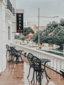 een rij zwarte tafels en stoelen op een balkon bij Wifi Boutique Hotel in George Town