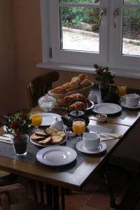 a table with a breakfast of bread and orange juice at Grange de la Herde in Camon