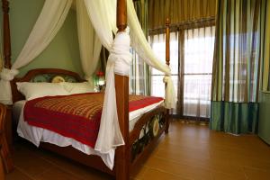花蓮市的住宿－璞拉漫ㄚ瑪，一间卧室配有一张带天蓬的床