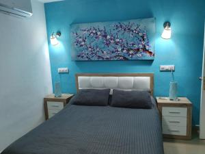 1 dormitorio con 1 cama con una pintura en la pared en LA GONDOLA, en Puerto de Mogán