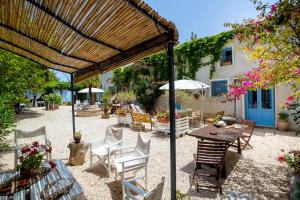 a patio with a table and chairs and a building at Le Case dello Zingaro in Contrada Sauci Grande